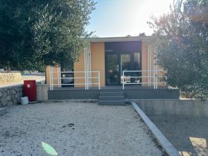 uma casa com um alpendre e uma porta em Camp Milo Moje em Drvenik