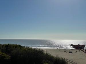 una playa con un muelle y el océano en Riazor Sol y Arena en San Clemente del Tuyú