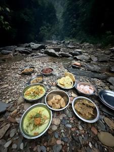 a group of plates of food on a rocky ground at Tropical Jungle Hut in Bukit Lawang