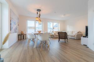 a dining room and living room with a table and chairs at 36 Grad in Garding