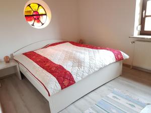 a bedroom with a bed and a stained glass window at Backboord in Poppenbüll