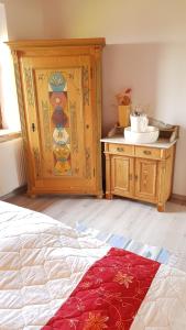 a bedroom with a wooden cabinet and a red rug at Backboord in Poppenbüll