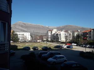 a group of cars parked in a parking lot with mountains in the background at Apartman in Trebinje