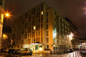 un grand bâtiment situé dans une rue de la ville la nuit dans l'établissement Belambra City - Magendie, à Paris