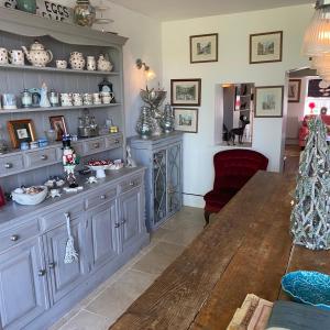 a living room with a table and a red chair at Immaculate historical 2-Bed Cottage in The Fens in Lutton