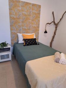 1 dormitorio con 2 camas con sábanas verdes y almohadas de color naranja en Finca Chimaca, en Arona