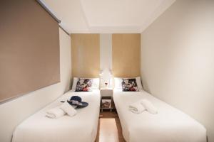 a room with two beds with hats on them at Homelikes Madrid in Madrid