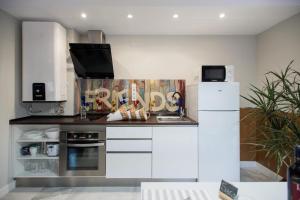 a kitchen with white cabinets and a white refrigerator at Homelikes Madrid in Madrid