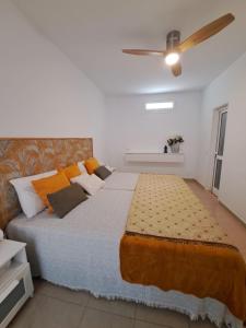 1 dormitorio con 1 cama grande y ventilador de techo en Finca Chimaca en Arona