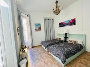 - une chambre avec 2 lits et un lustre dans l'établissement Malak-Rooms, à Malaga