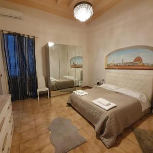 Un dormitorio con una cama grande y un espejo. en Accademia Studio, en Florencia
