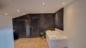 La salle de bains est pourvue d'une douche et d'une baignoire. dans l'établissement O Beau Cerf, à Sart-lez-Spa