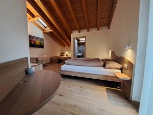 Großes Zimmer mit einem Bett und einem Tisch in der Unterkunft Agritur Clementi in Nave San Rocco