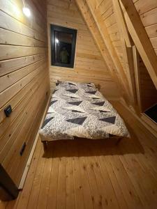 łóżko w drewnianym pokoju w kabinie w obiekcie Shpija e Liqenit w Prisztinie