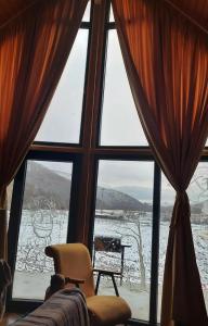 a window with a view of a snow covered yard at Shpija e Liqenit in Pristina