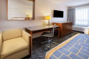 a hotel room with a desk and a bed and a chair at Days Inn by Wyndham Manassas Battlefield in Manassas
