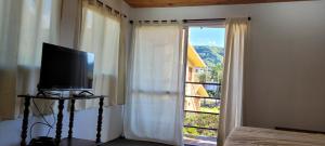 a bedroom with a television and a window with a view at Posada Rivera in San Salvador de Jujuy