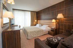a hotel room with a bed and a couch at Hotel Palas in Petrovac na Moru
