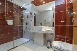 a bathroom with a sink and a shower and a toilet at Hotel Palas in Petrovac na Moru