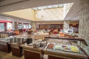 a restaurant with tables and chairs in a building at Hotel Palas in Petrovac na Moru