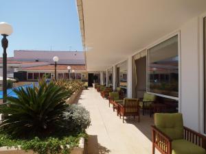 a row of chairs and tables on a building at Hotel Palas in Petrovac na Moru