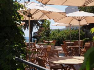 an outdoor patio with tables and chairs with umbrellas at Hotel Palas in Petrovac na Moru