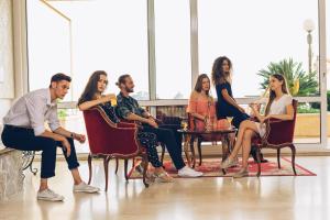 a group of people sitting in chairs in a room at Hotel Palas in Petrovac na Moru