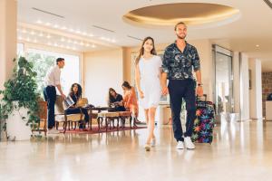 a man and a woman walking through a lobby at Hotel Palas in Petrovac na Moru