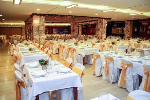 a large banquet hall with white tables and chairs at Hotel Palas in Petrovac na Moru