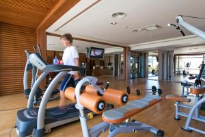 a woman running on a treadmill in a gym at Hotel Palas in Petrovac na Moru