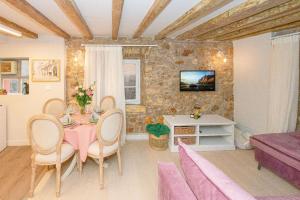 een woonkamer met een tafel en stoelen bij Casa Trenta Otto-J in Corfu-stad