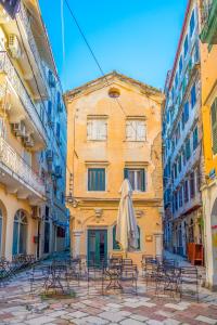 een groep stoelen en een paraplu op straat bij Casa Trenta Otto-J in Corfu-stad