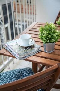 uma mesa de madeira com uma chávena de café e um jornal em Lea and Maks's City Apartment URBAN STAY em Zagreb