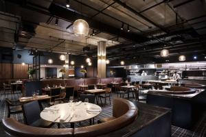 a restaurant with tables and chairs and a bar at Hilton Adelaide in Adelaide