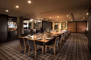 uma longa sala de jantar com uma longa mesa e cadeiras em Hilton Adelaide em Adelaide
