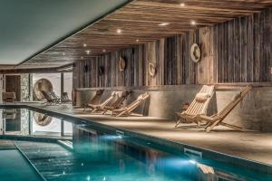 um grupo de cadeiras sentadas ao lado de uma piscina em Le Refuge de Solaise - 2551 m Altitude em Val dʼIsère