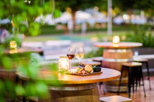 uma mesa com dois copos de vinho e um prato de comida em DoubleTree by Hilton Cairns em Cairns