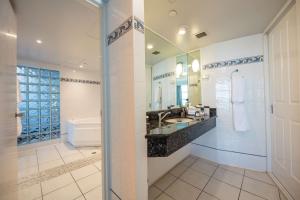Un baño con lavabo, inodoro y espejo. en DoubleTree by Hilton Cairns, en Cairns