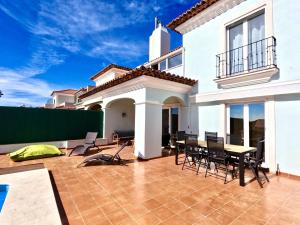 a patio of a house with chairs and a table at Casa Beloura between the sea and the mountains in Sintra