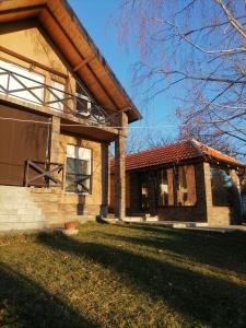 a house with a porch and a grass yard at A Bre Da Bre Family Club in Niš