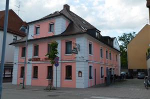 un edificio rosa y blanco en el lateral de una calle en Hotel Birnbaum, en Ansbach