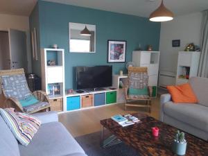 uma sala de estar com um sofá e uma televisão em Duin en zee em Bredene