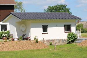 een wit huis met een zwart dak bij Ferienhaus Ostseeblick in Munkbrarup