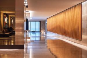 a hallway in a hotel with a lobby with a glass wall at Parmelia Hilton Perth in Perth