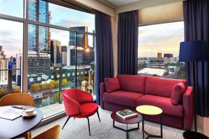 a living room with a red couch and a large window at DoubleTree by Hilton Melbourne in Melbourne