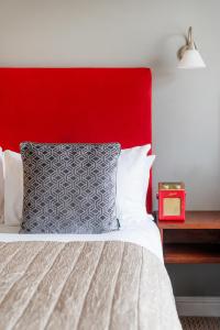 a bedroom with a red headboard and a bed at The Clifton Hotel Bristol in Bristol