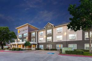 an exterior view of a hotel with a parking lot at La Quinta by Wyndham Rockwall in Rockwall