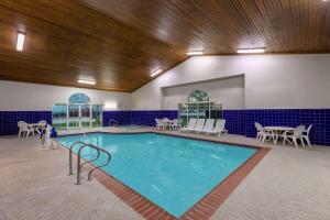 uma grande piscina com cadeiras e uma mesa em La Quinta by Wyndham Rockwall em Rockwall