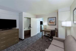 a hotel room with a couch and a desk and a television at La Quinta by Wyndham Rockwall in Rockwall