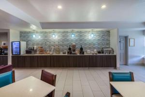 a restaurant with a counter and tables and chairs at La Quinta by Wyndham Rockwall in Rockwall